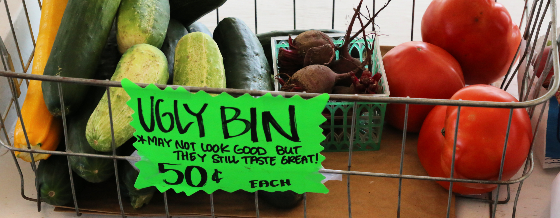 An ugly bin at a farmers market with imperfect fruit.