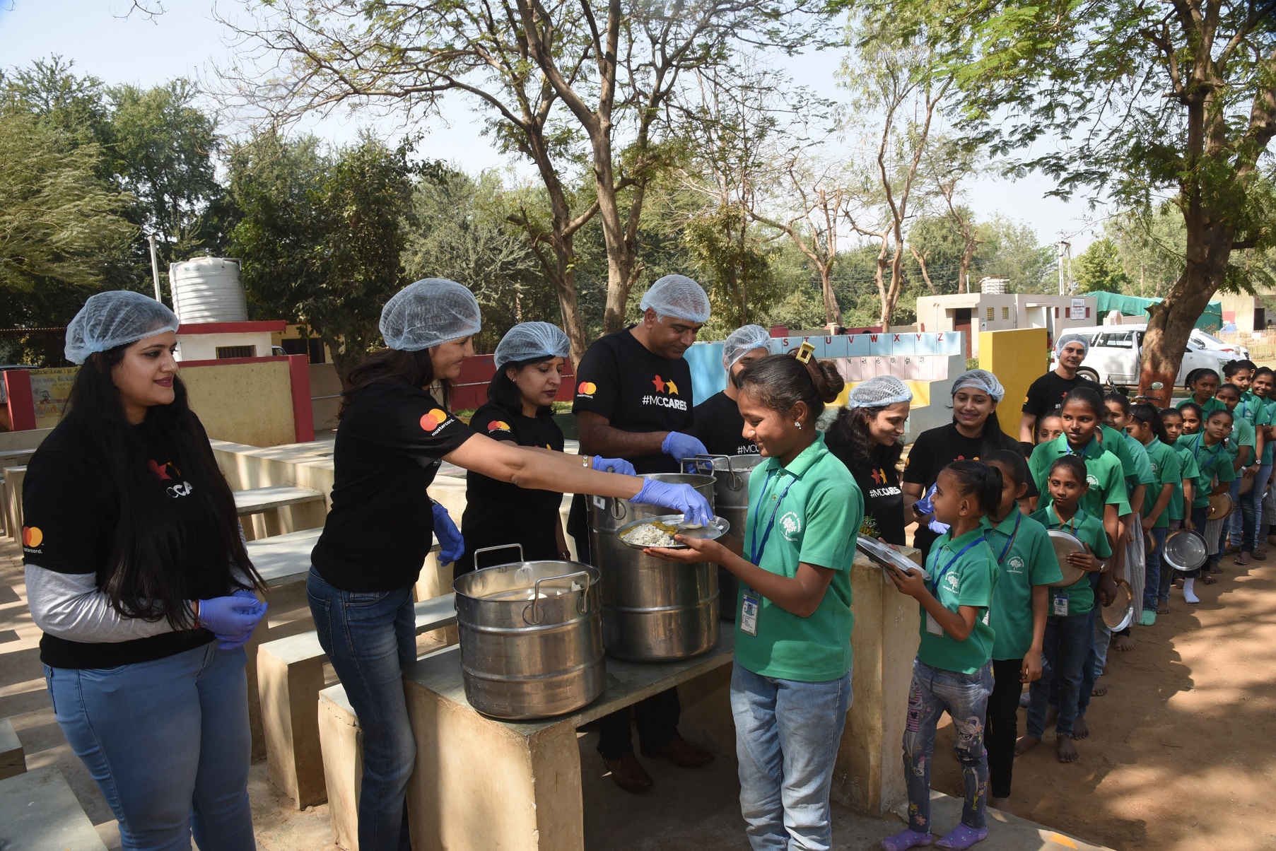 Deepak Mahbubani along with other Mastercard team members distributing mid-day meals at the Dhorivaga school in Vadodara