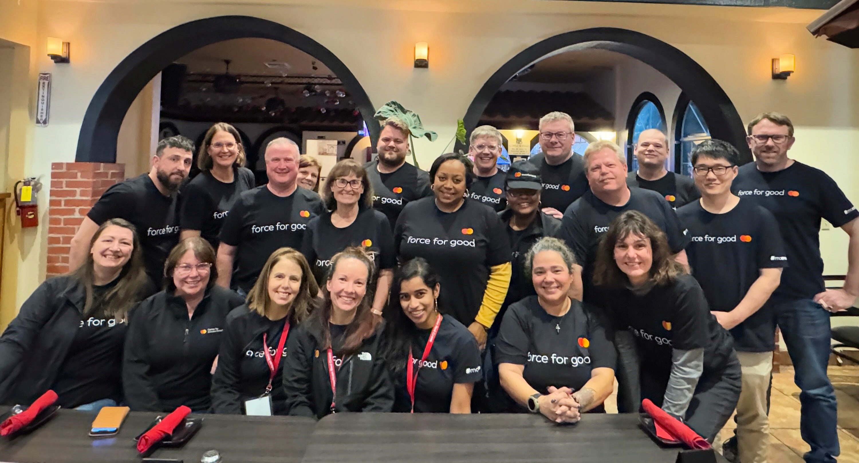 Mastercard volunteers in front of a table at a restaurant.