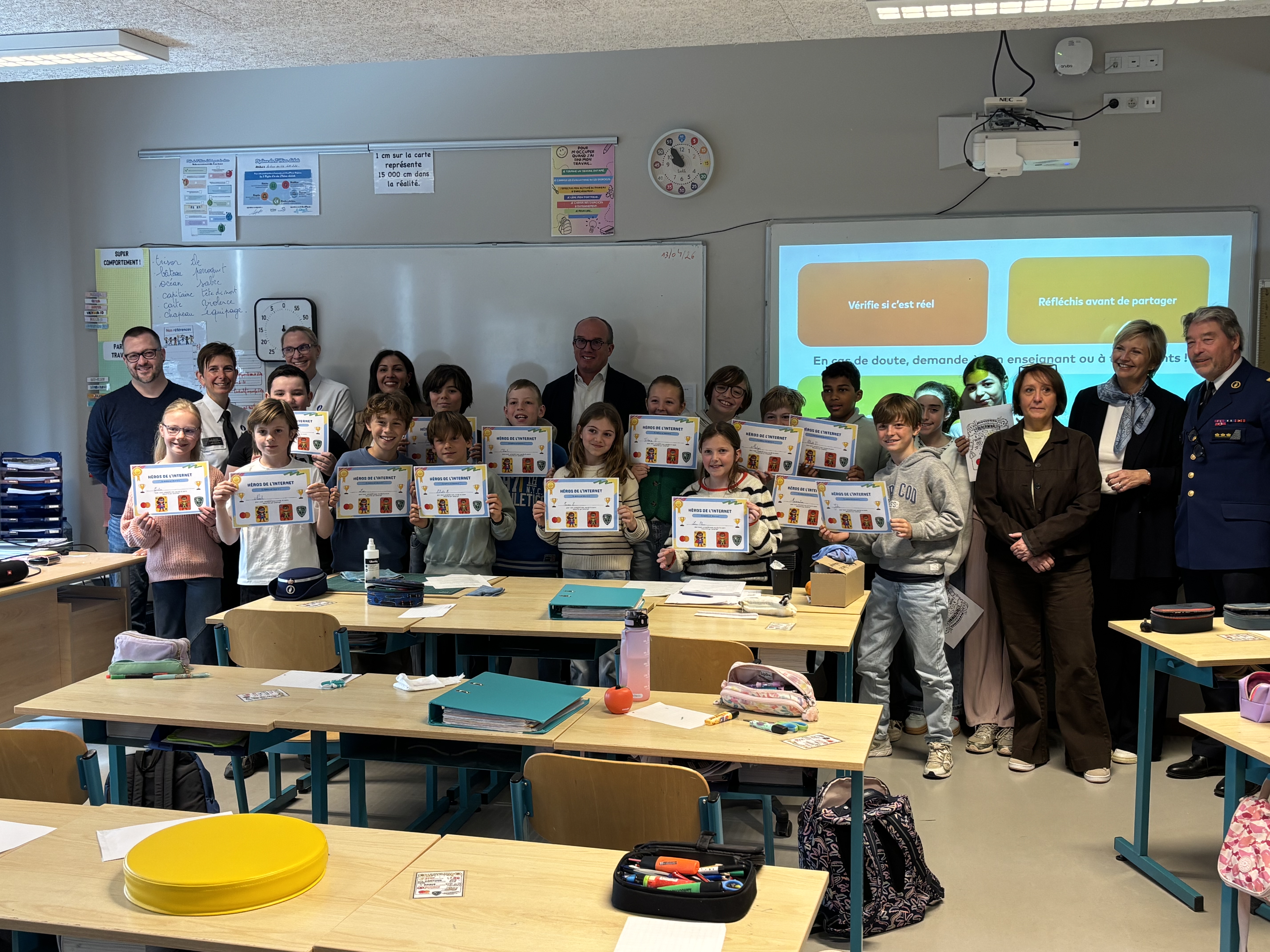 Aux côtés des élèves participants, Florence Reuter, bourgmestre de Waterloo, et Michel Vandewalle, chef de corps de la police locale, soutiennent cette initiative de sensibilisation à la cybersécurité menée à l’école communale de Mont‑Saint‑Jean.