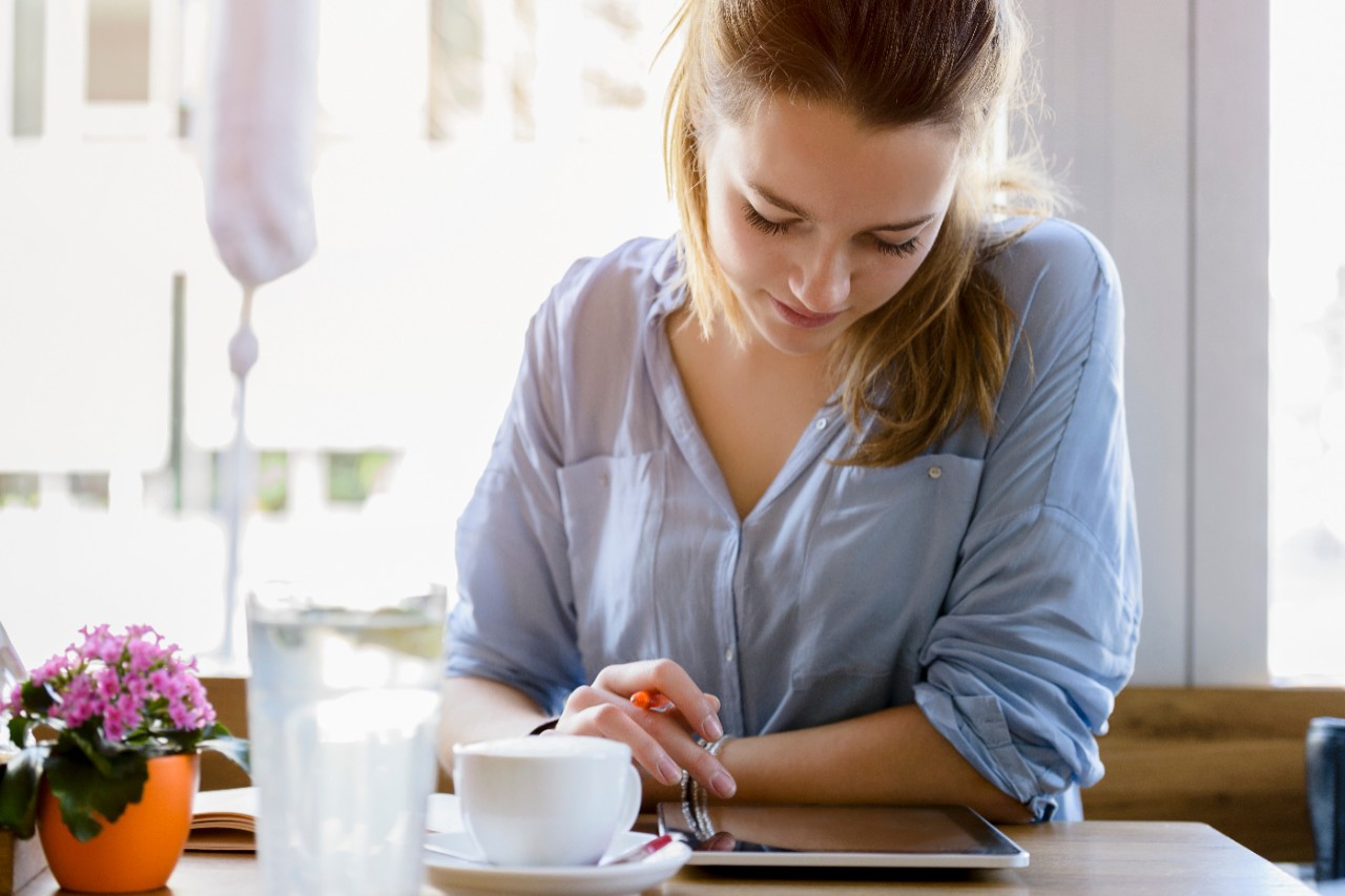 Eine Frau regelt im Wohnzimmer ihre Finanzen