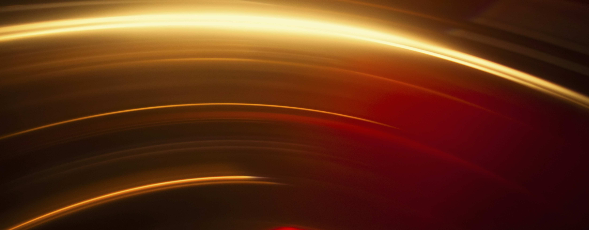 Abstract image of vibrant red and gold light trails against black background