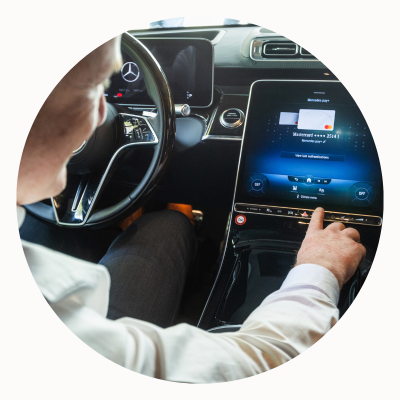 A man uses a touchscreen in his car to make a payment.