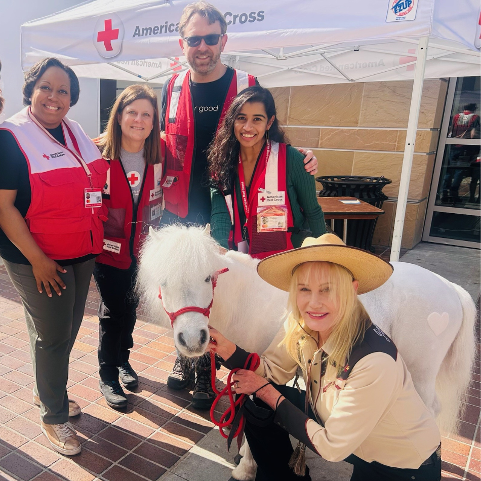 Four Red Cross volunteers with actress Daryl Hannah and one of her Shetland ponies outside a Red Cross shelter.