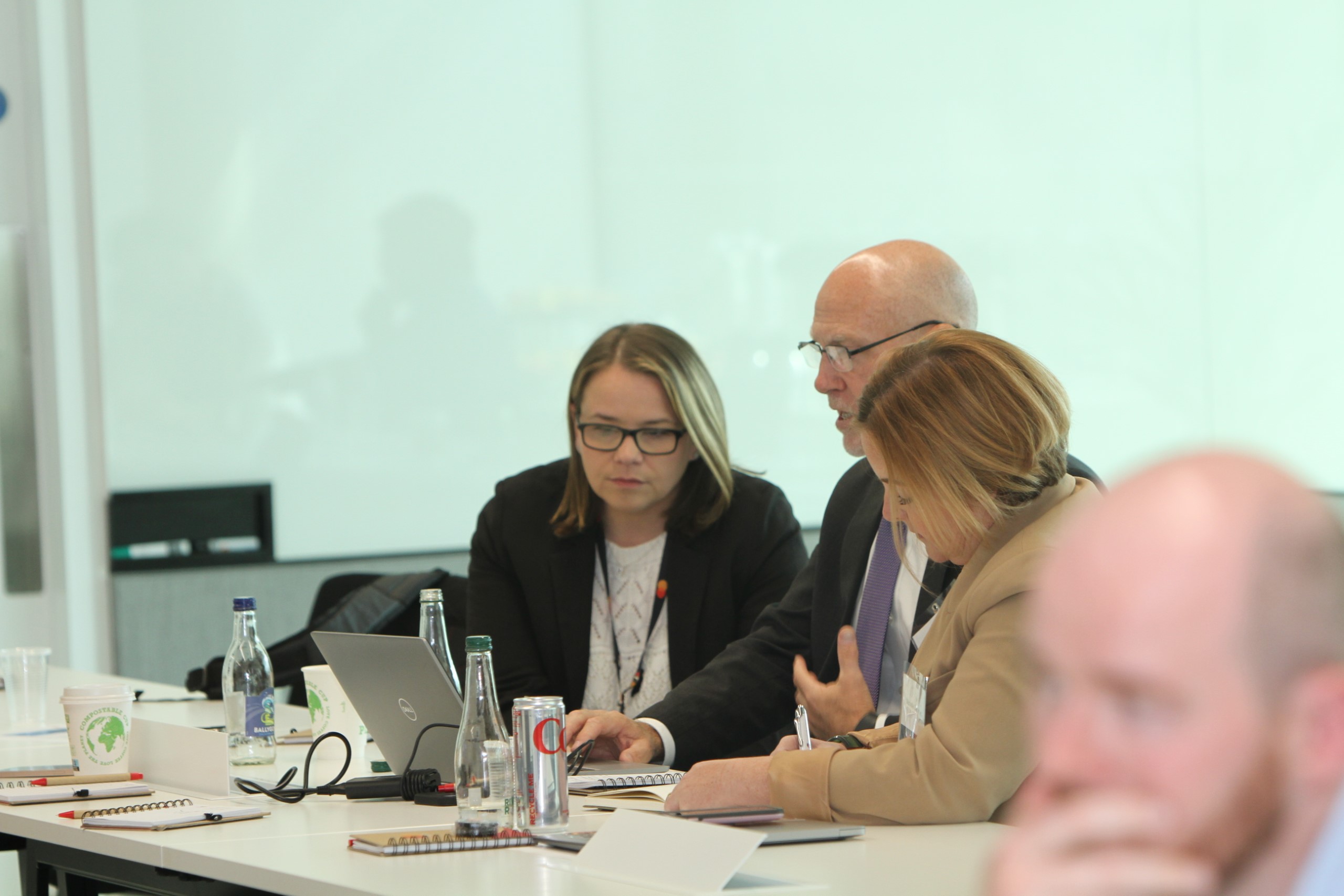 Mastercard's Marie Hansen, left and Michael Lashlee, center, work through a potential response to a disinformation attack at the company's annual threatcasting exercise with Michelle Garrigan, right, from Bank of America.